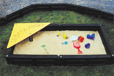 Sandbox 4 x 8 With Corner Table backyard sandbox with black frame, yellow corner table featuring numeric figures, and colorful sand toys