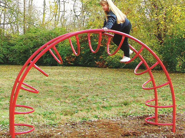Red half-moon shaped climbing frame with curved rungs and child climbing on grass outdoors