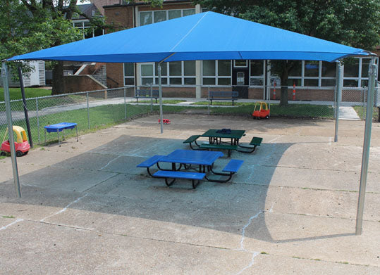 Pyramid Shade Structure with 4 Posts in blue providing UV protection and cooling shade over picnic tables on playground pavement