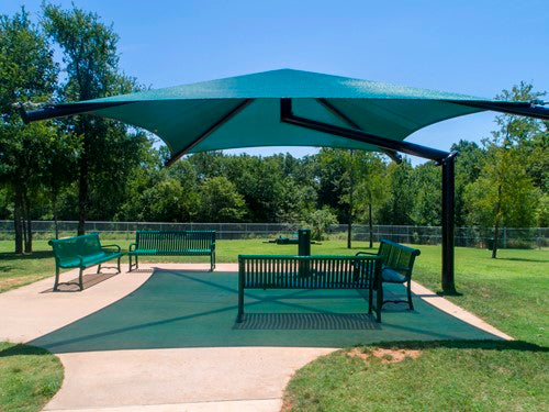 Single post pyramid cantilever shade with teal UV-blocking fabric over green benches on concrete pad in park setting