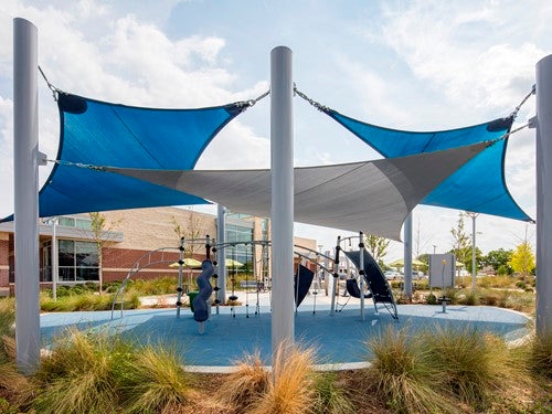 Four-point hypar sail shade with blue and gray hyperbolic fabric panels supported by tall columns over playground equipment