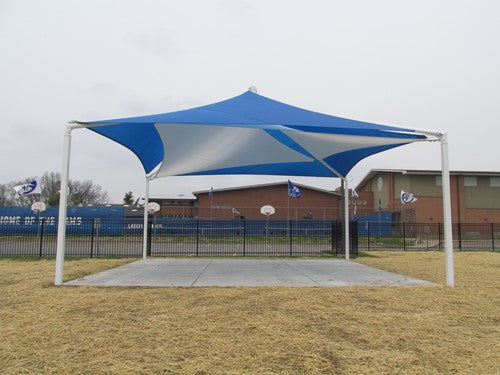 Blue and white layered fabric pyramid shade structure with four white support poles over a concrete pad in an outdoor schoolyard