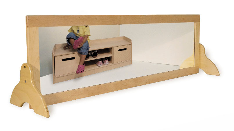 Wide children's mirror with solid hardwood frame and shatterproof plexiglass reflecting a child seated on a wooden storage bench