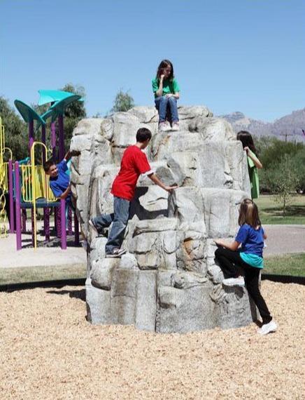 Granite climbing boulder with realistic rock texture, children climbing and sitting, outdoor playground setting