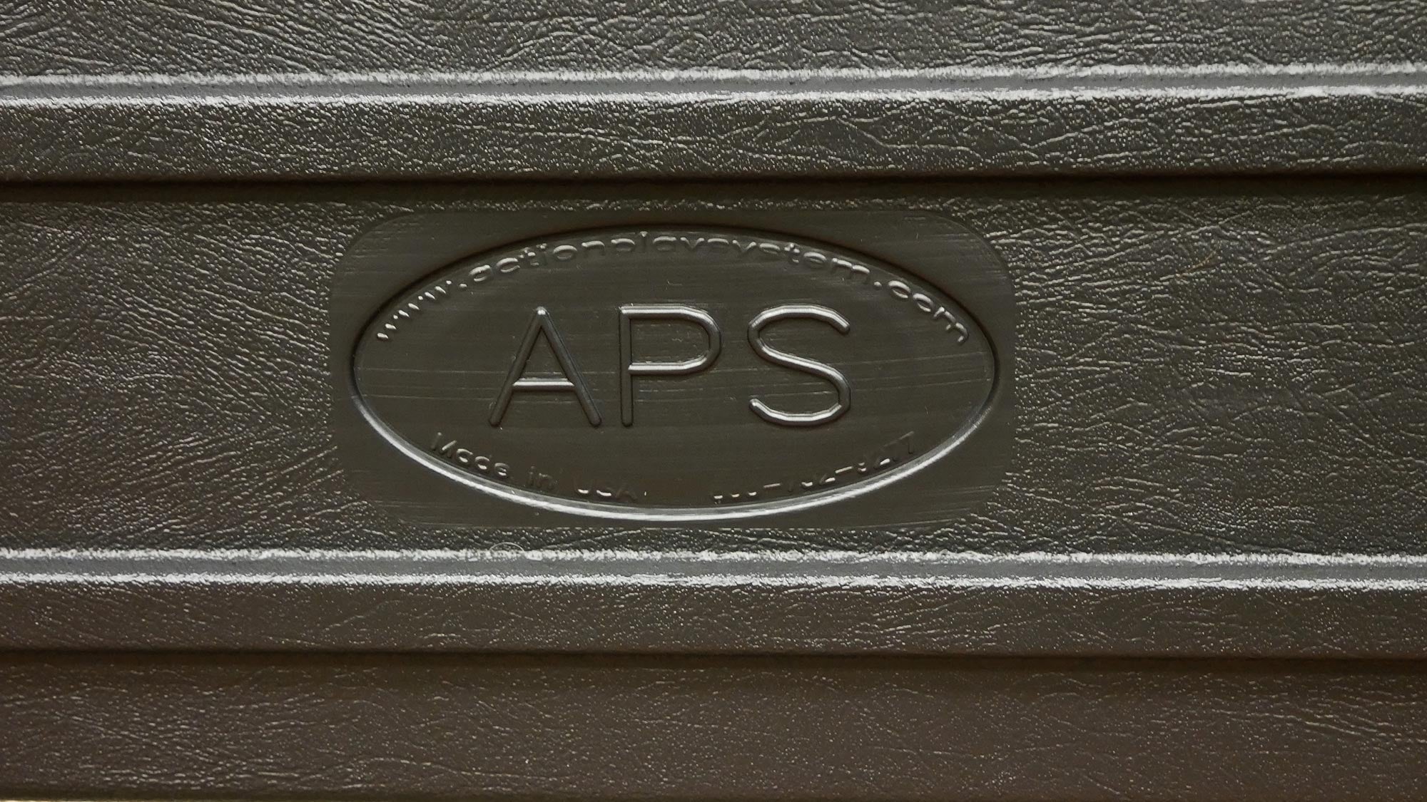 Close-up of textured dark brown plastic panel with embossed APS logo and website detail on portable GaGa Ball pit panel