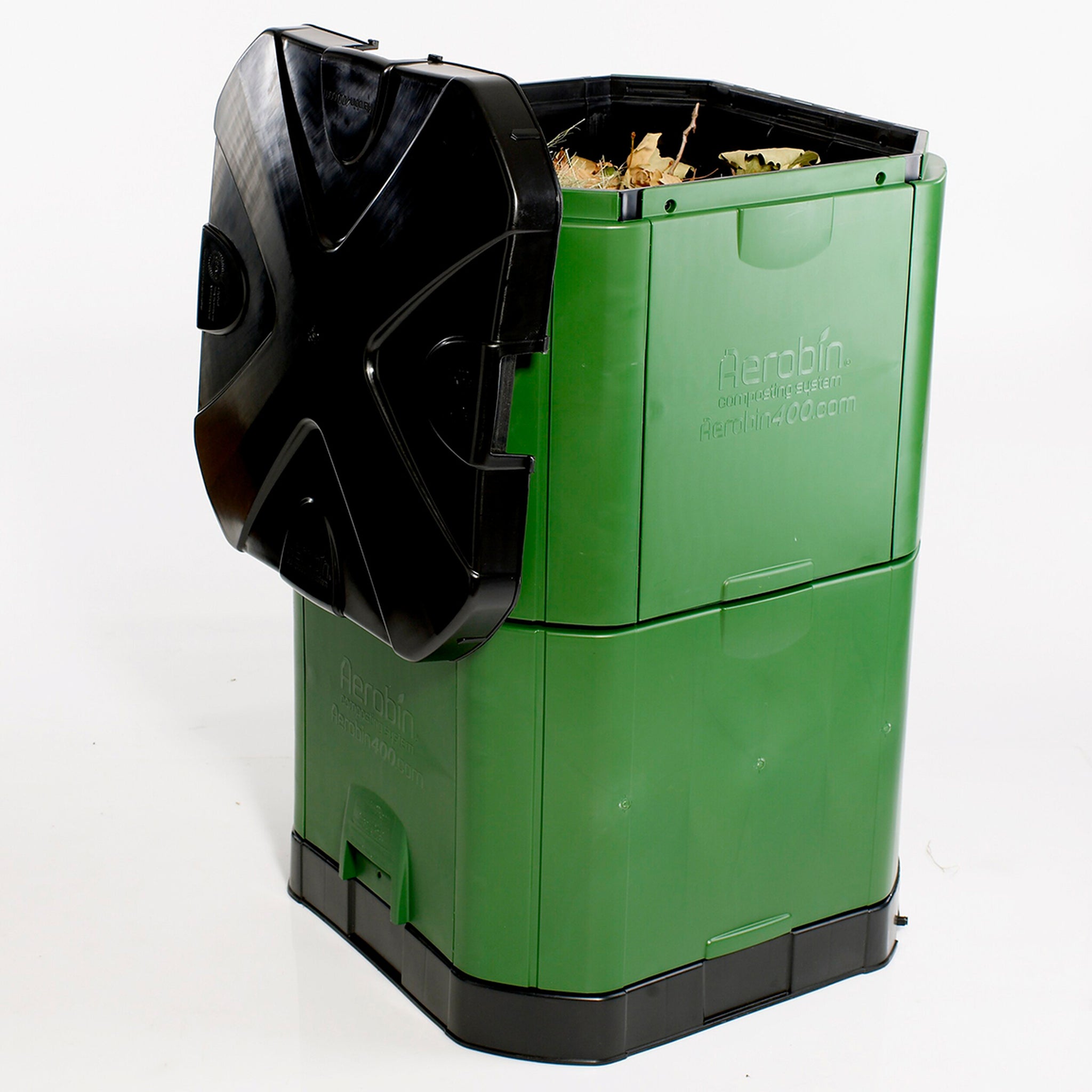 Green insulated compost bin with black lid open, showing organic waste inside, designed for efficient aerobic composting with heat retention and leachate collection.
