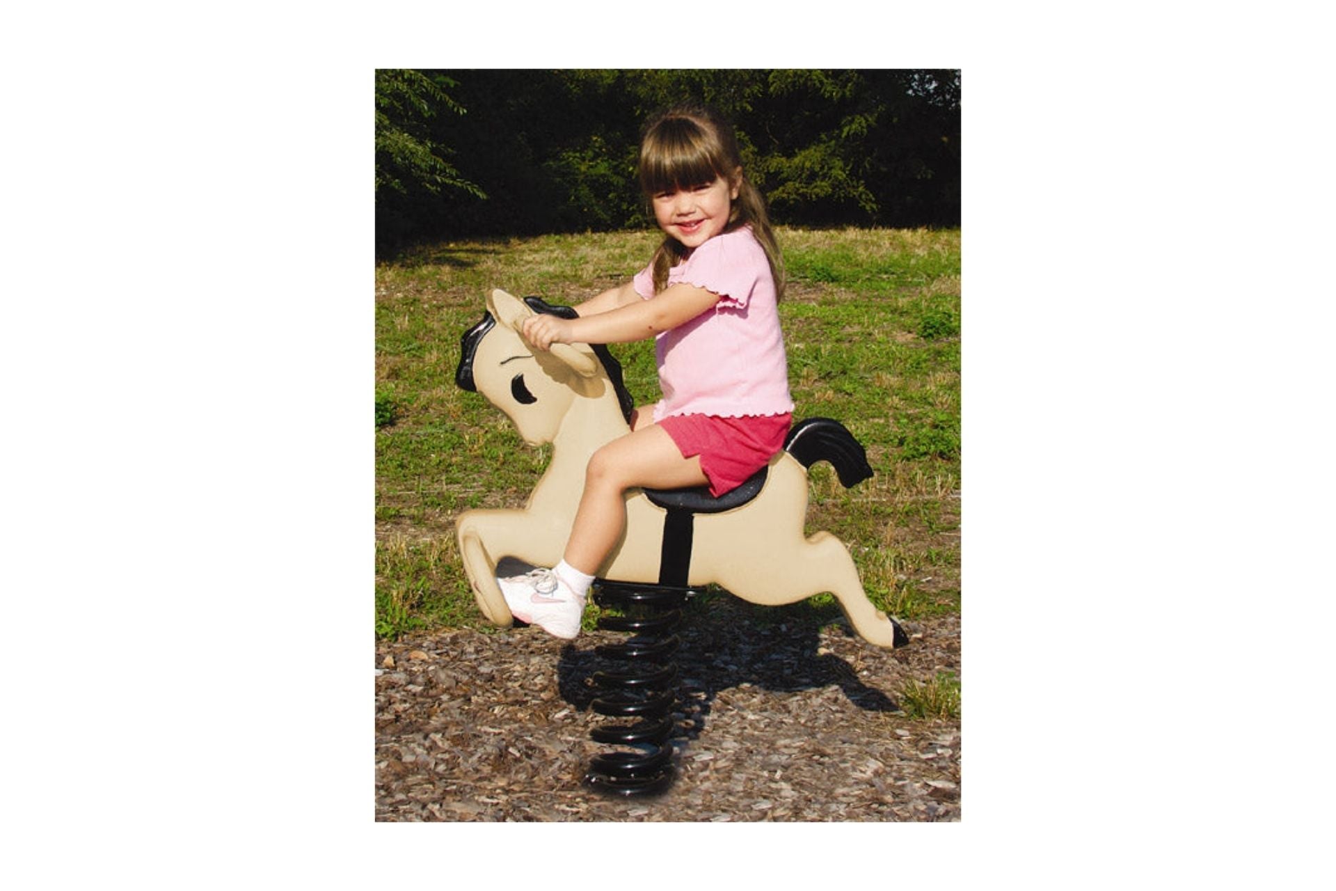 Bronco Easy Rider playground spring rider shaped like beige pony with black mane and tail on wood chip surface outdoors