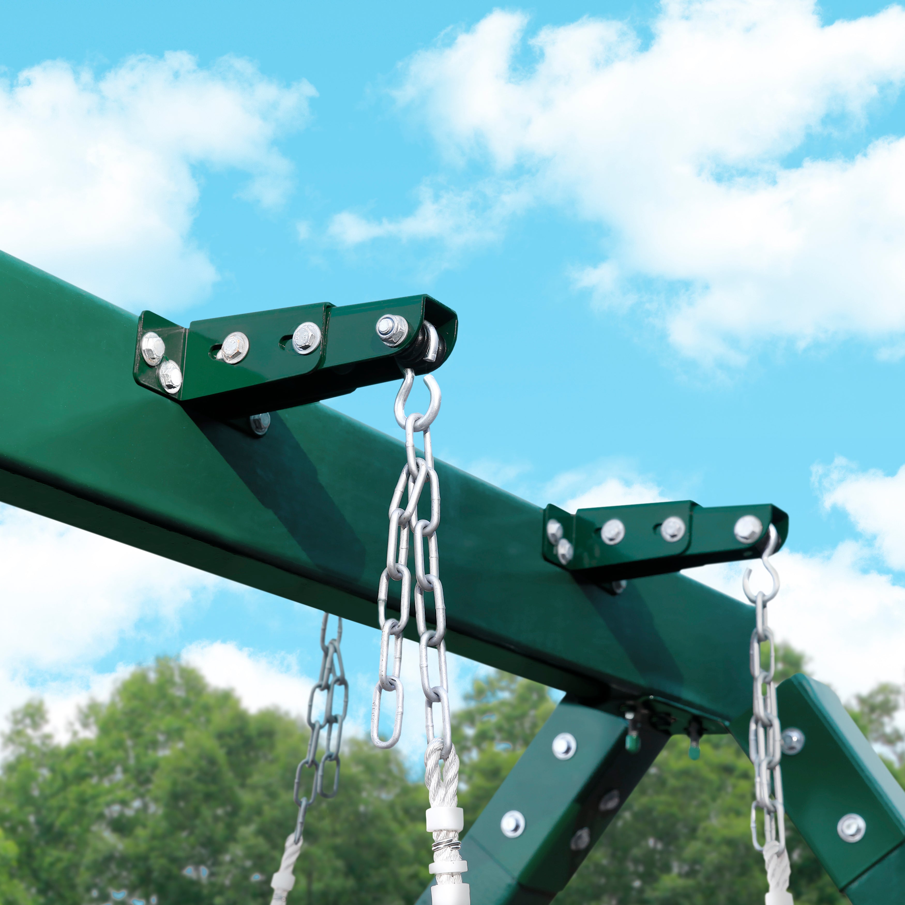 Glider Swing Brackets steel pair mounted on green swing set beam with hanging chains against blue sky