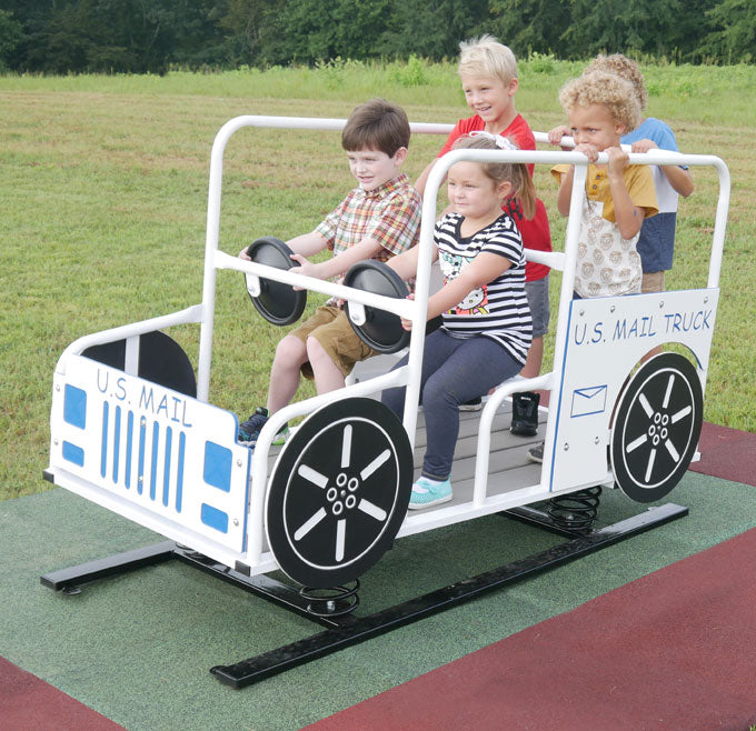 Multi-child spring rider shaped like a mail truck with interactive steering wheels on a playground surface