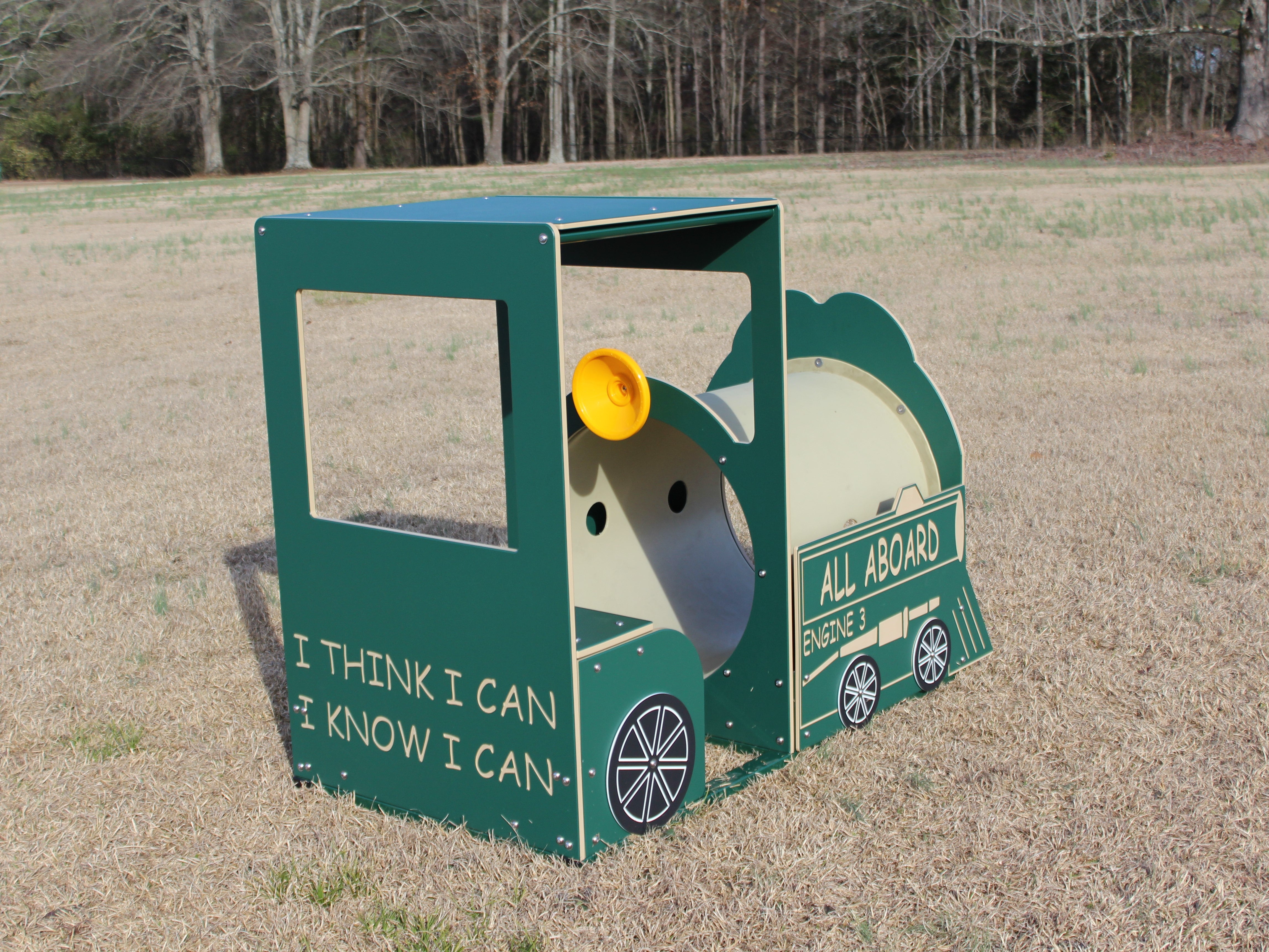 Train Engine playground equipment with green and cream crawl-through tunnel, yellow horn, metal bar seat for two, and steering wheel on grass