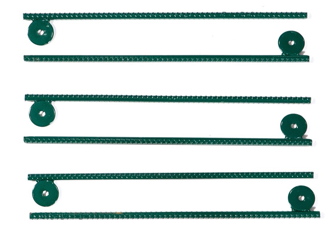 Overhead view of six green metal ground stakes with circular mounting tabs for securing playset leveling blocks