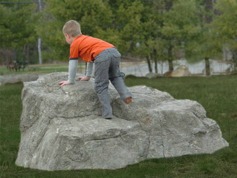 Little Foot Climbing Boulder with child climbing on textured, durable outdoor play rock in natural setting