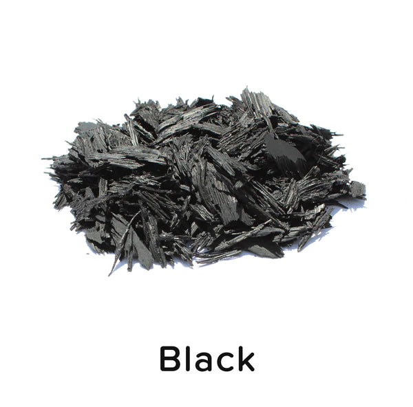 Pile of jagged black recycled rubber mulch pieces for durable, low-maintenance playground surfacing and landscaping ground cover
