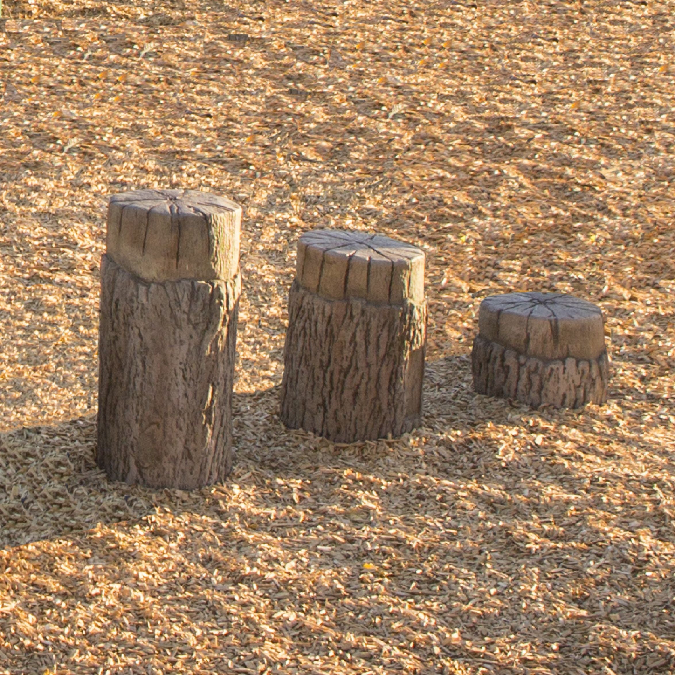 Nature Themed Tree Stump Steppers set of 3 with realistic bark texture on wood chip playground surface, varying heights