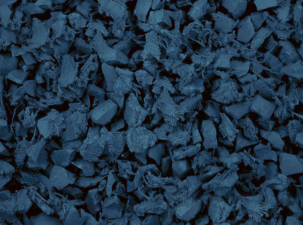 Close-up of irregularly shaped blue recycled rubber playground mulch pieces with textured surfaces for safe, durable playground surfacing