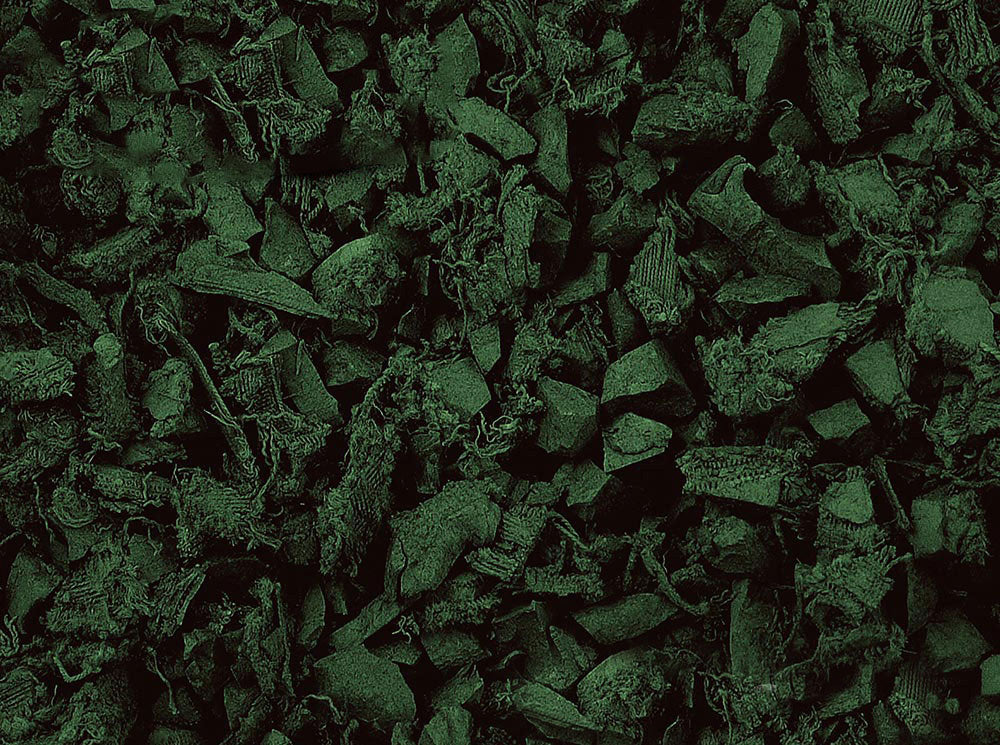 Close-up of dark green recycled rubber playground mulch pieces with varied textures and soft, shock-absorbing surface
