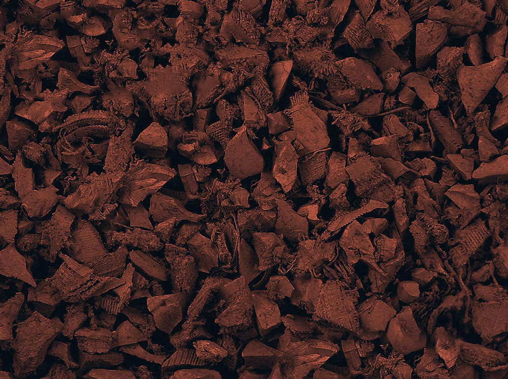 Close-up of textured, irregular red recycled rubber playground mulch pieces with a soft, springy surface for safe play areas