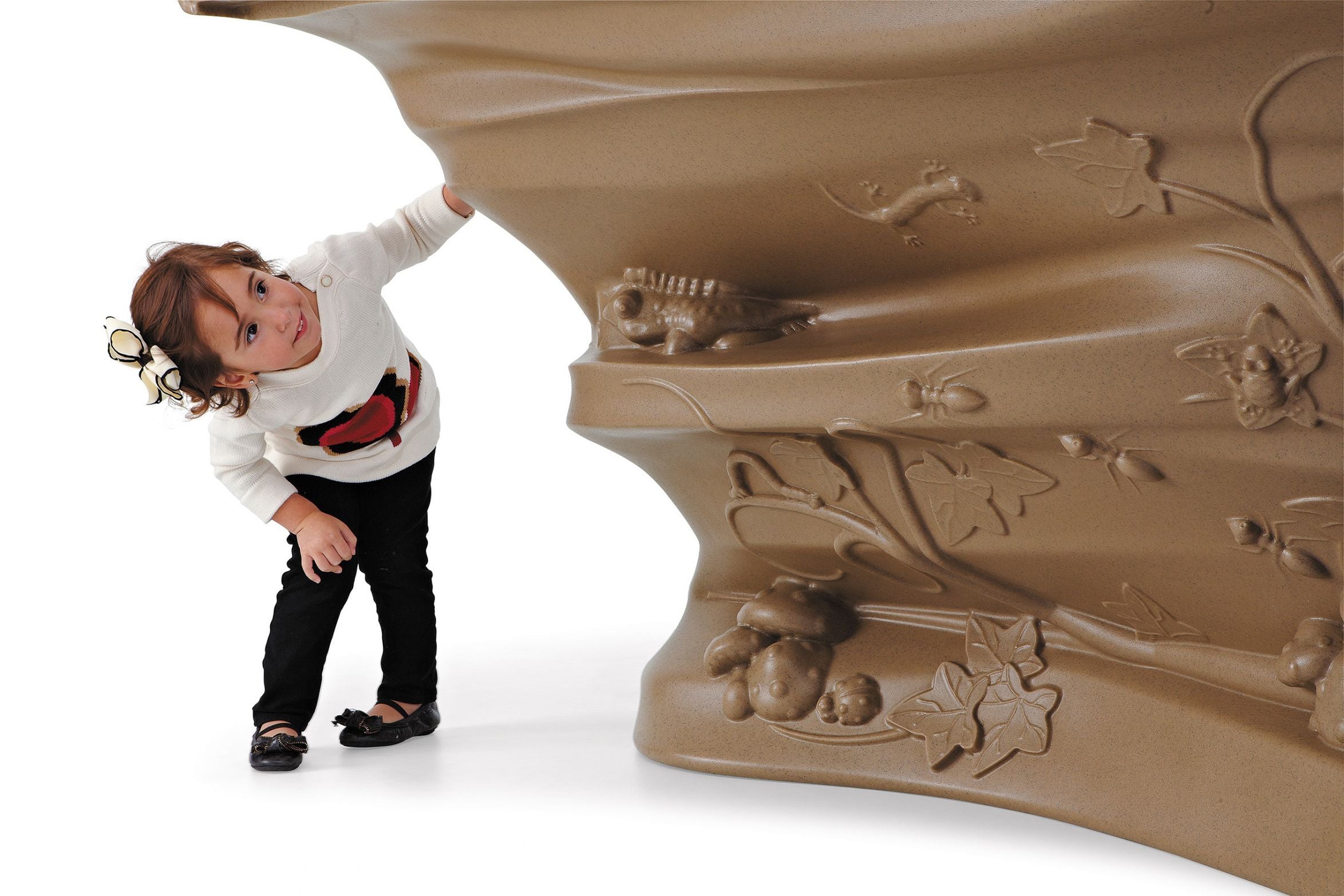 Child climbing a nature-inspired play structure with leaves, insects, and small animal details promoting exploration and adventure