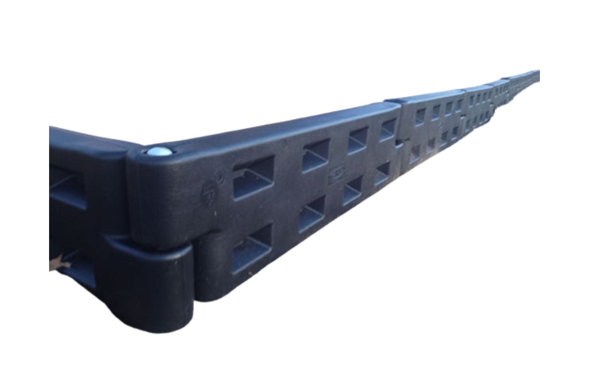 Black plastic interlocking playground border with spike and rectangular cutouts, angled close-up showing textured surface and connection design