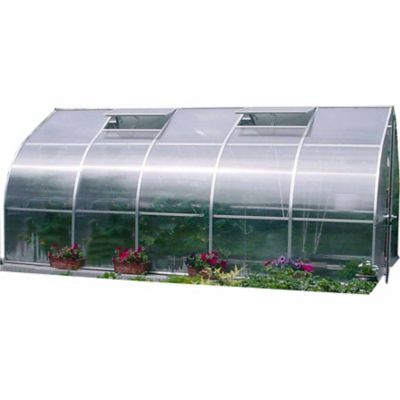 Large curved greenhouse with 8mm twin-wall polycarbonate panels, roof vents, barn-style door, and flower beds along the base