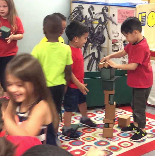 Children playing indoors with colorful eco-friendly recycled plastic building blocks on a patterned rug