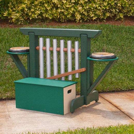 Green outdoor musical storage bench with six metal chimes and two side drums on concrete surface