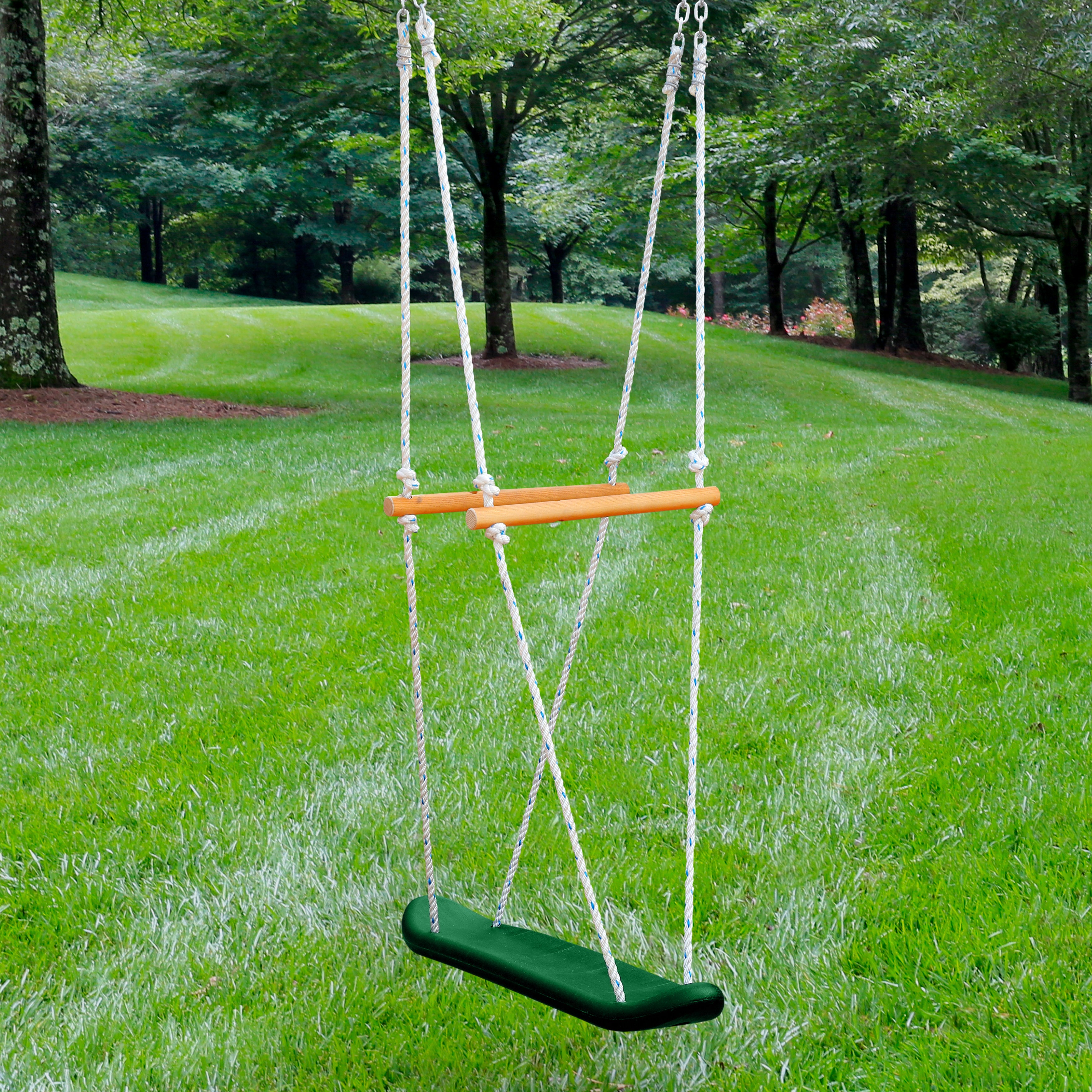 Green molded plastic skateboard swing seat with wooden handles suspended by white ropes over grass outdoors