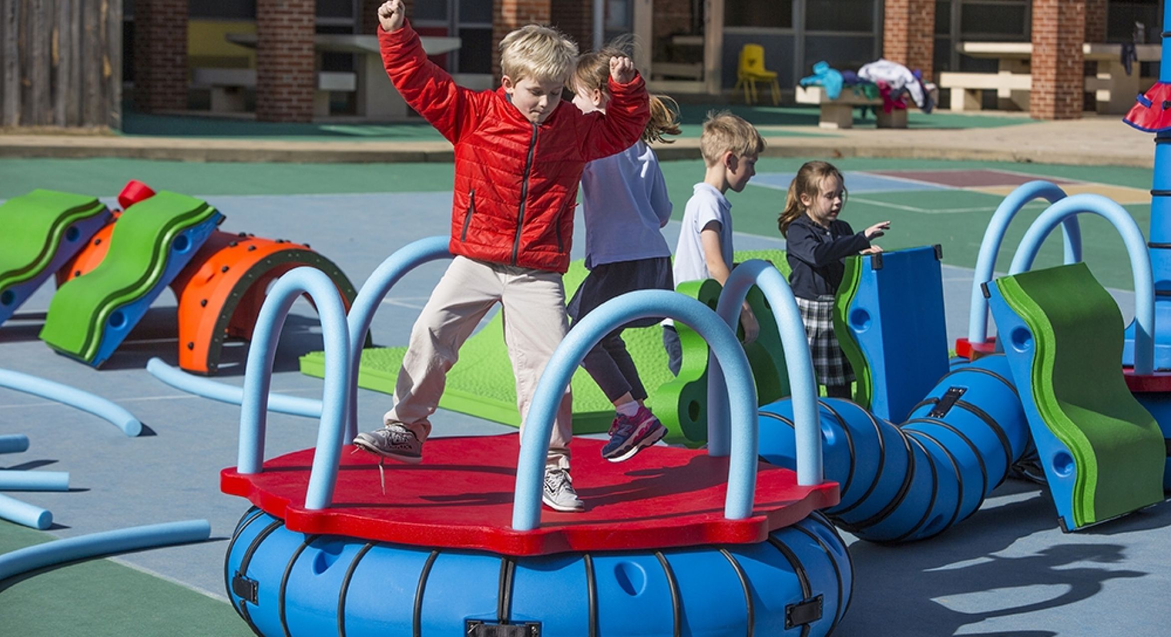 Children playing on colorful modular outdoor playground with climbing, balancing, and interactive learning features