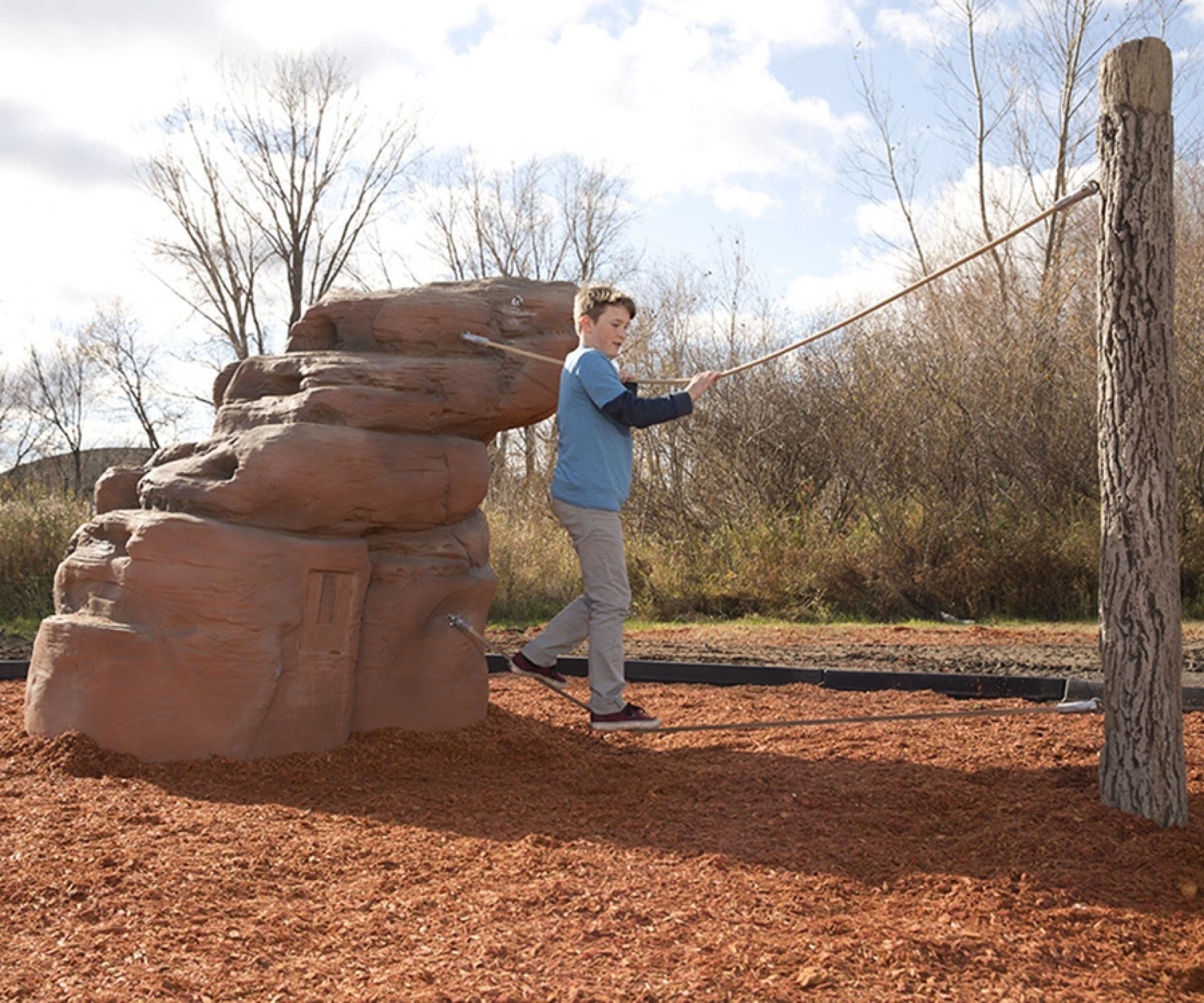 Nature Rocks Mount Hayden Climbing Rock with child climbing sandstone boulder, log post, and rope balance elements for outdoor play
