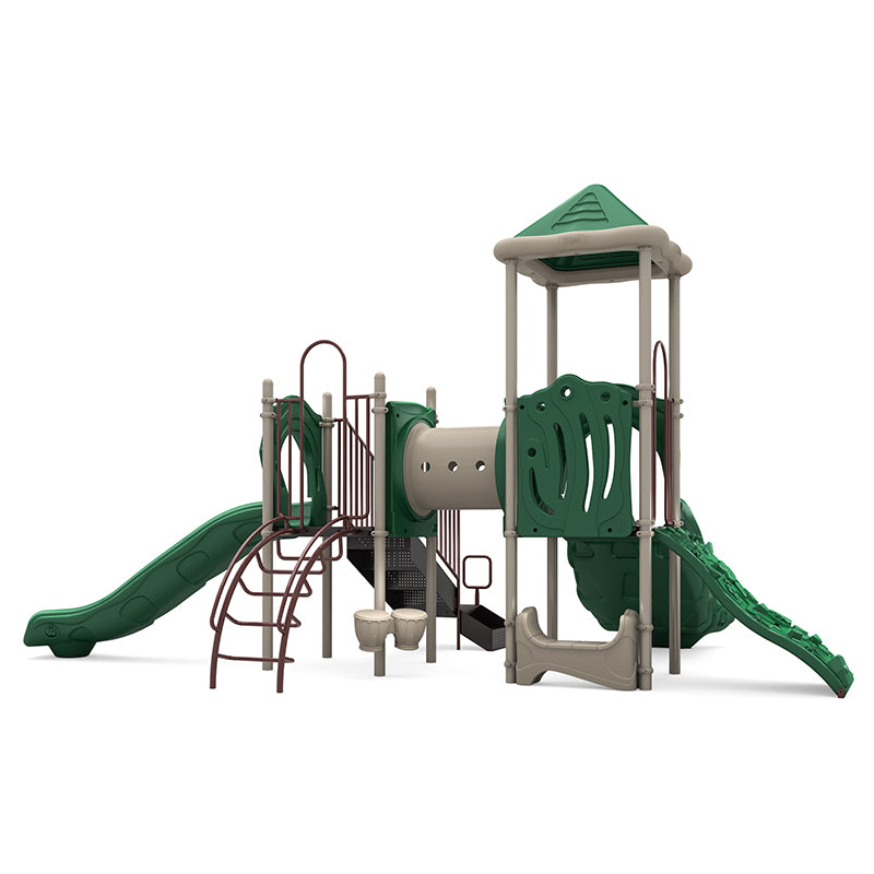 Outdoor playground structure with green double and single slides, rock climbing wall, crawl tunnel, bongo drums, and saddle seat