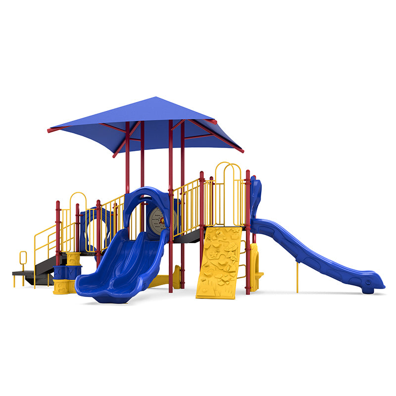 Shady Pines Playground with blue double and single slides, yellow rock climber, large blue shade canopy, and interactive play panels