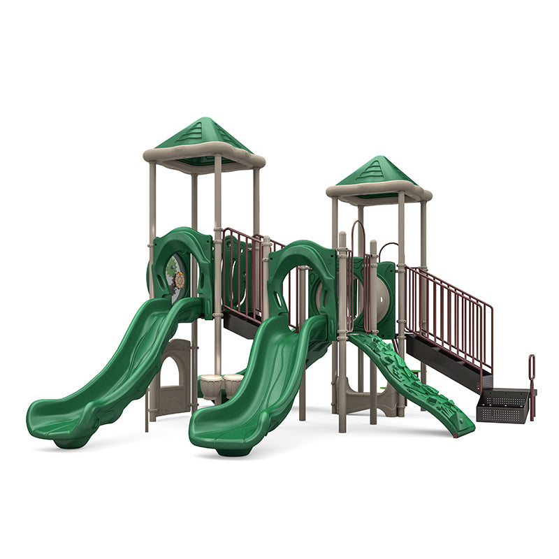Playground structure with two green slides, climbing wall, crawl tunnel, gears panel, and neutral-toned pyramid roofs