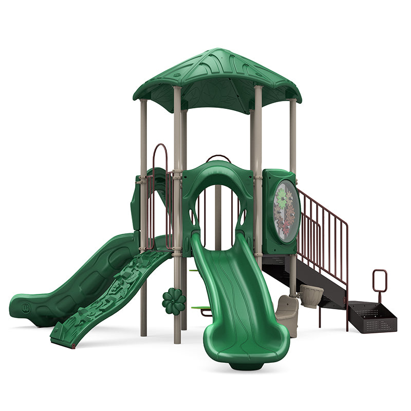 Green playground structure with double and single slides, rock climber, gears panel, rain wheel, and musical bongo under a leaf-patterned roof