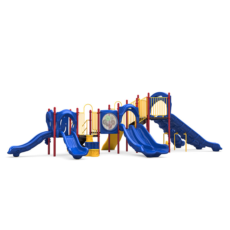 Commercial playground system with blue triple, double, and single slides, rock climber, gear panel, and yellow safety rails.