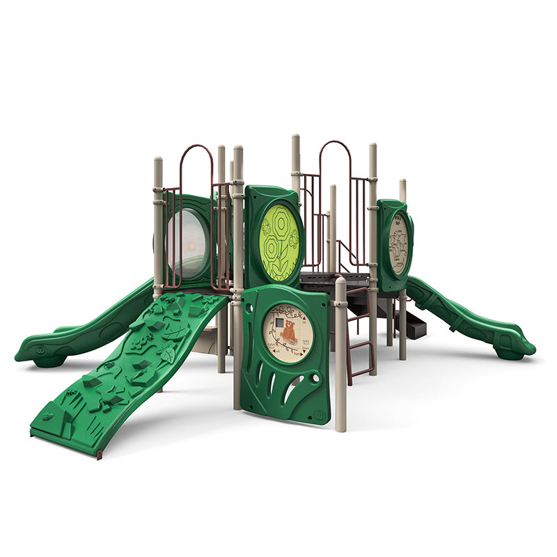 Green modular playground with two slides, rock climber, ladders, and interactive panels featuring maps, puzzles, and gears.