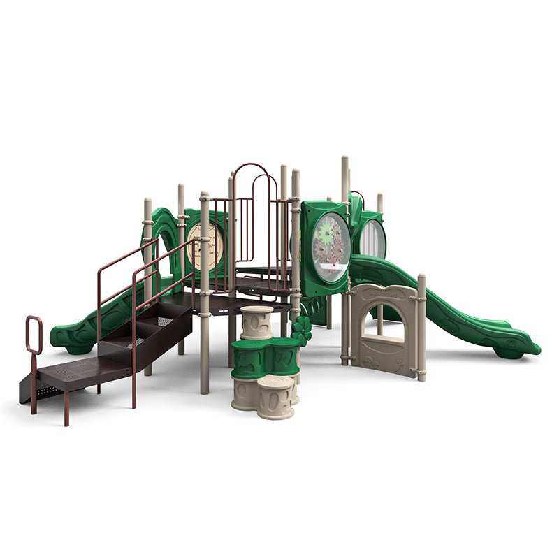 Green and tan commercial playground structure with dual slides, ramp, gear and counter panels, tree-stump climber, and interactive play elements