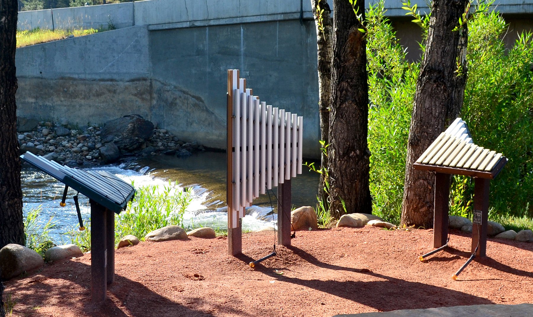 Weenotes Collection Outdoor Musical Park Instrument trio with metal bars on stands by riverside in natural park setting