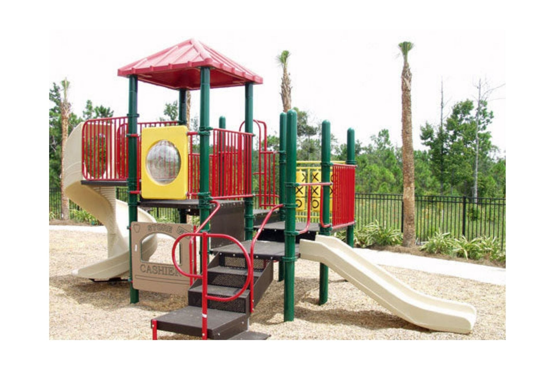Outdoor modular playground with spiral and straight slides, tic tac toe panel, bubble window, and climbing stairs in red, green, and beige.