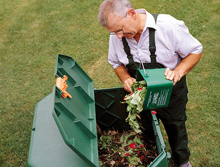 Aeroquick Composter with hinged lid, side doors, durable green polypropylene bin outdoors with airflow panel design