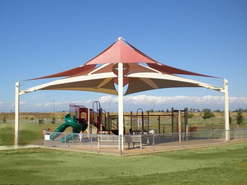 Superspan Multi-Level Multi-Panel Pyramid Shade Structure with layered fabric panels over playground equipment in an open park setting