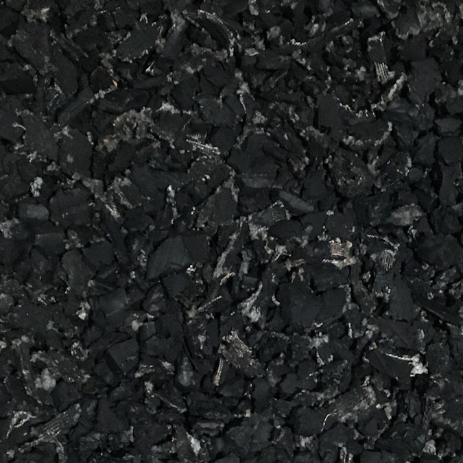 Close-up of textured black recycled rubber playground mulch with irregular pieces for safe, durable surfacing