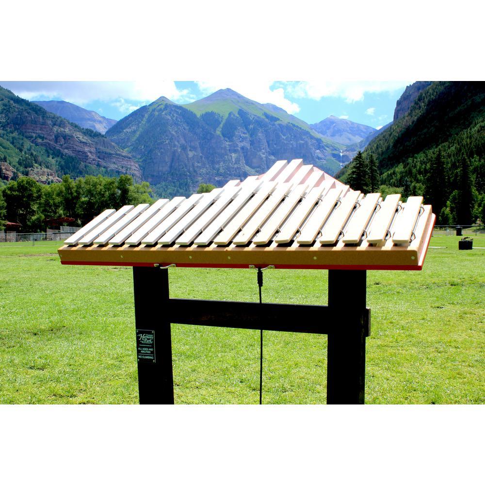 Outdoor metallophone with aluminum keys and blue trim mounted on black stand in grassy mountain park setting