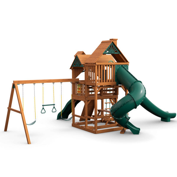 Wooden playset with green spiral slide, straight slide, two swings, trapeze bar, and multi-level deck with roof