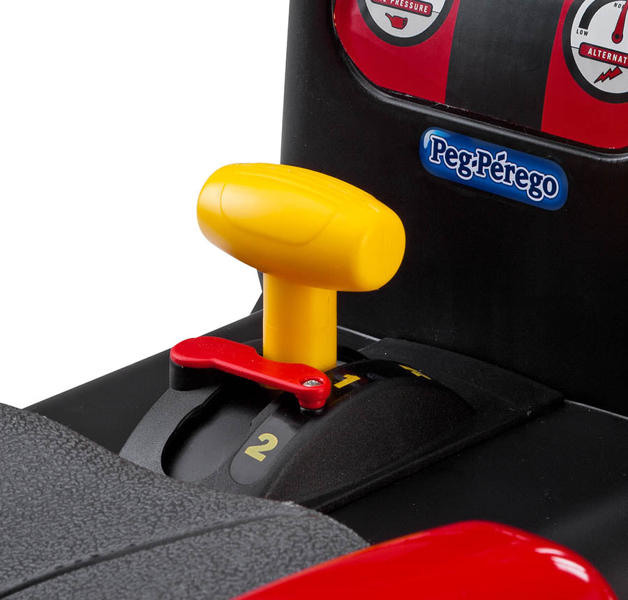 Close-up of red and black ride-on tractor control panel with yellow gear shift and Peg-Pérego logo