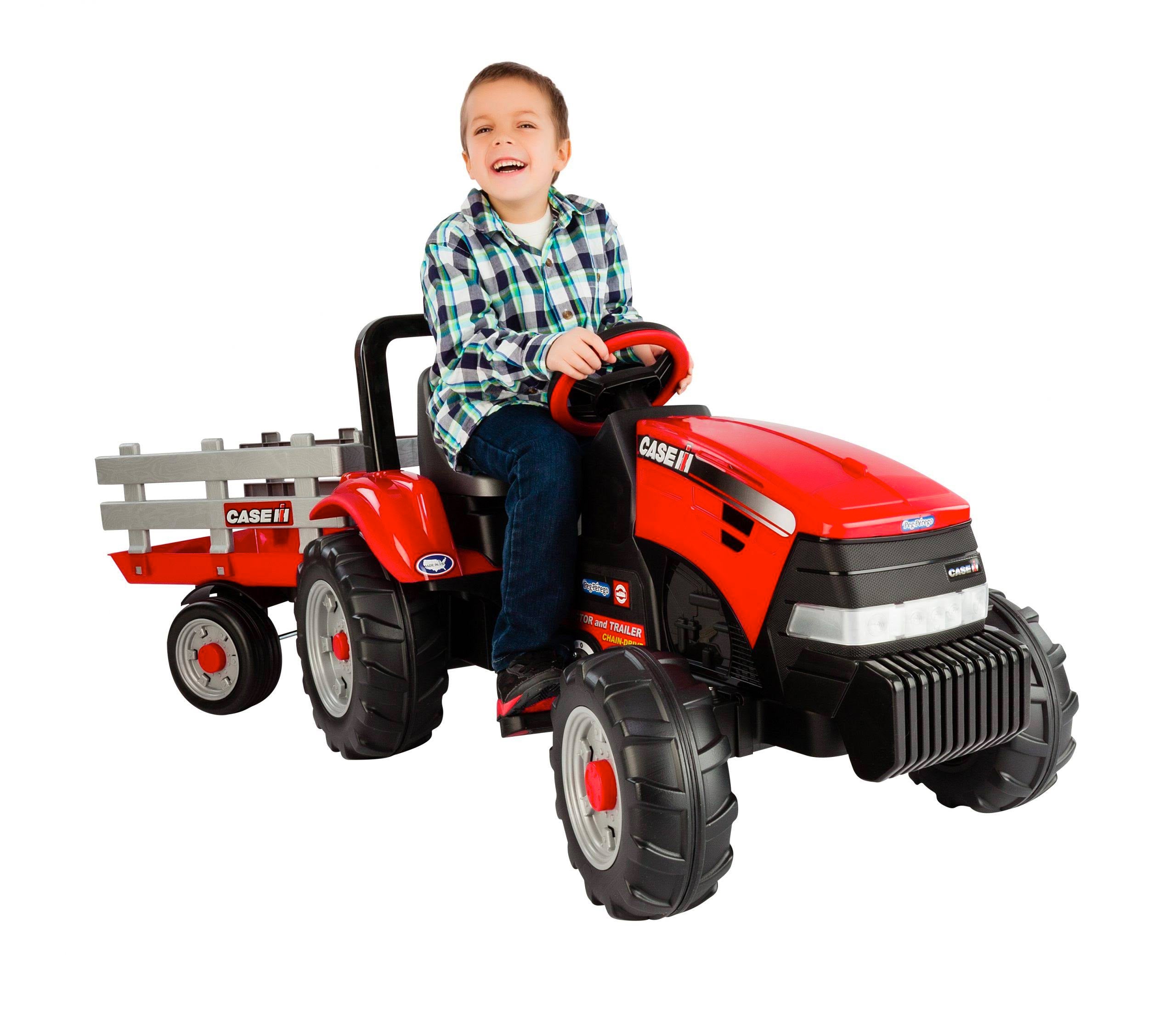 Child on red pedal tractor with detachable stake-side trailer and large rugged wheels for outdoor play and exercise