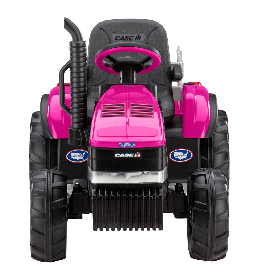 Pink ride-on toy tractor with black wheels, steering wheel, seat, and brand logos, featuring a detachable stake-side trailer.