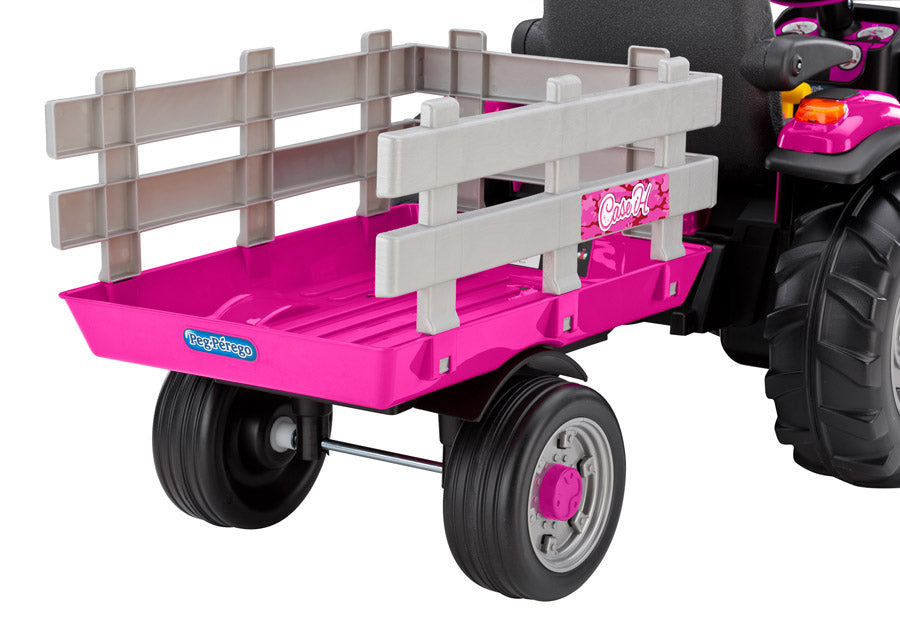 Pink children's ride-on tractor with detachable gray stake-side trailer and black wheels for outdoor play