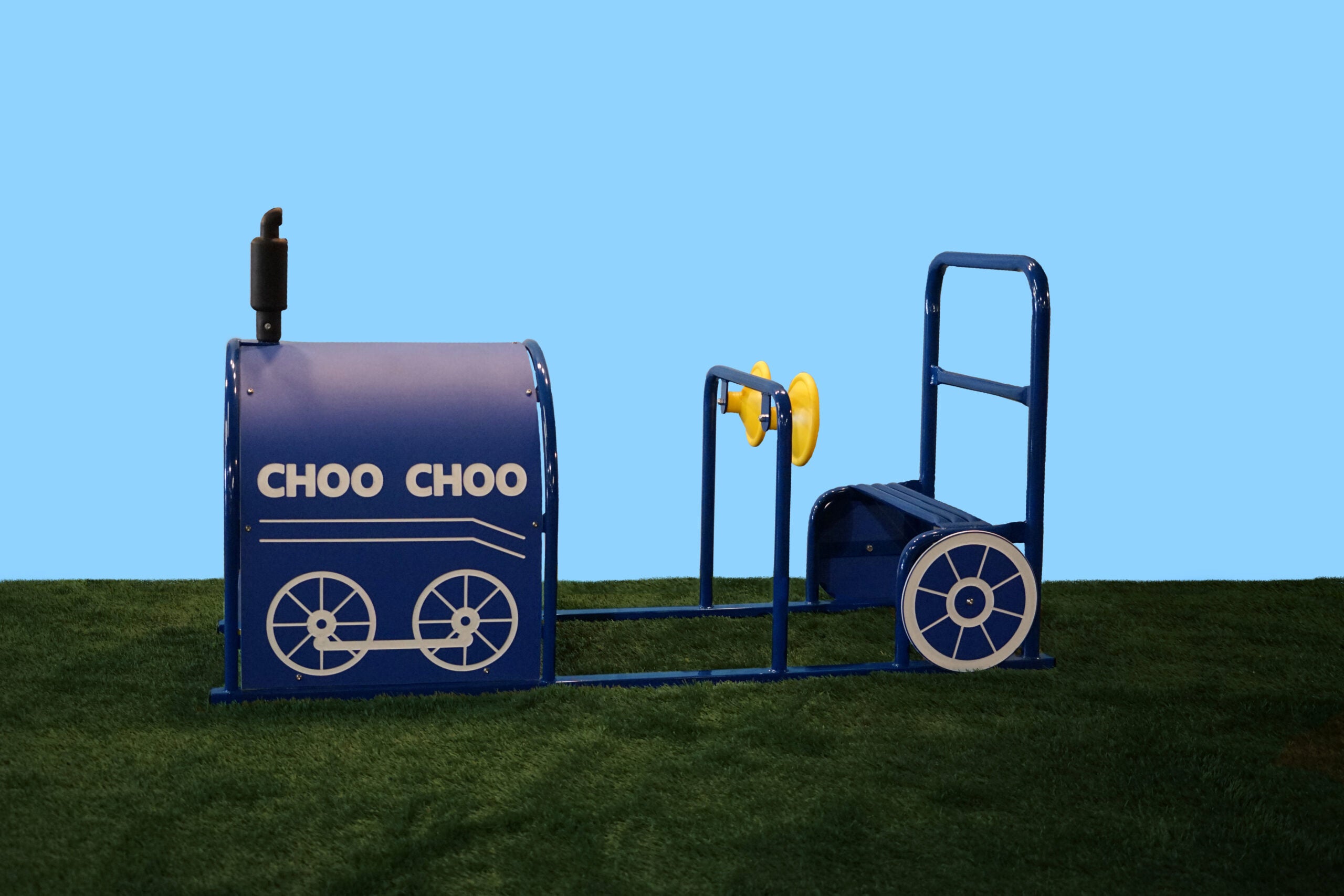 Blue metal children's train play structure with yellow steering wheel and white wheel designs on artificial grass