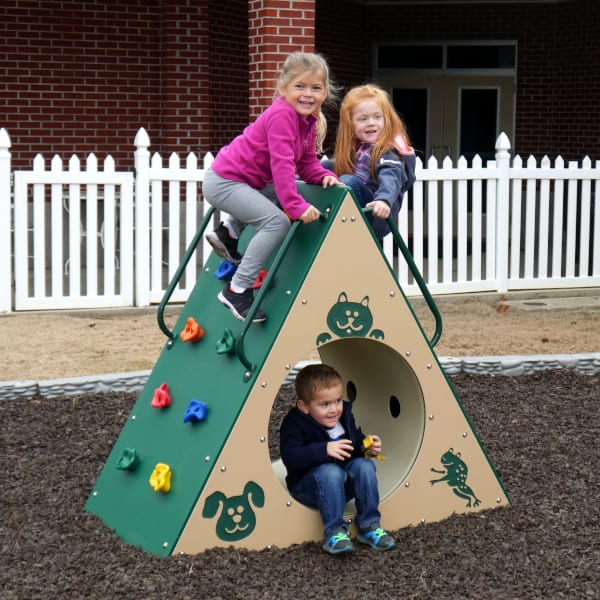 Green and beige triangular climbing wall with tunnel featuring animal graphics, children climbing and playing outdoors
