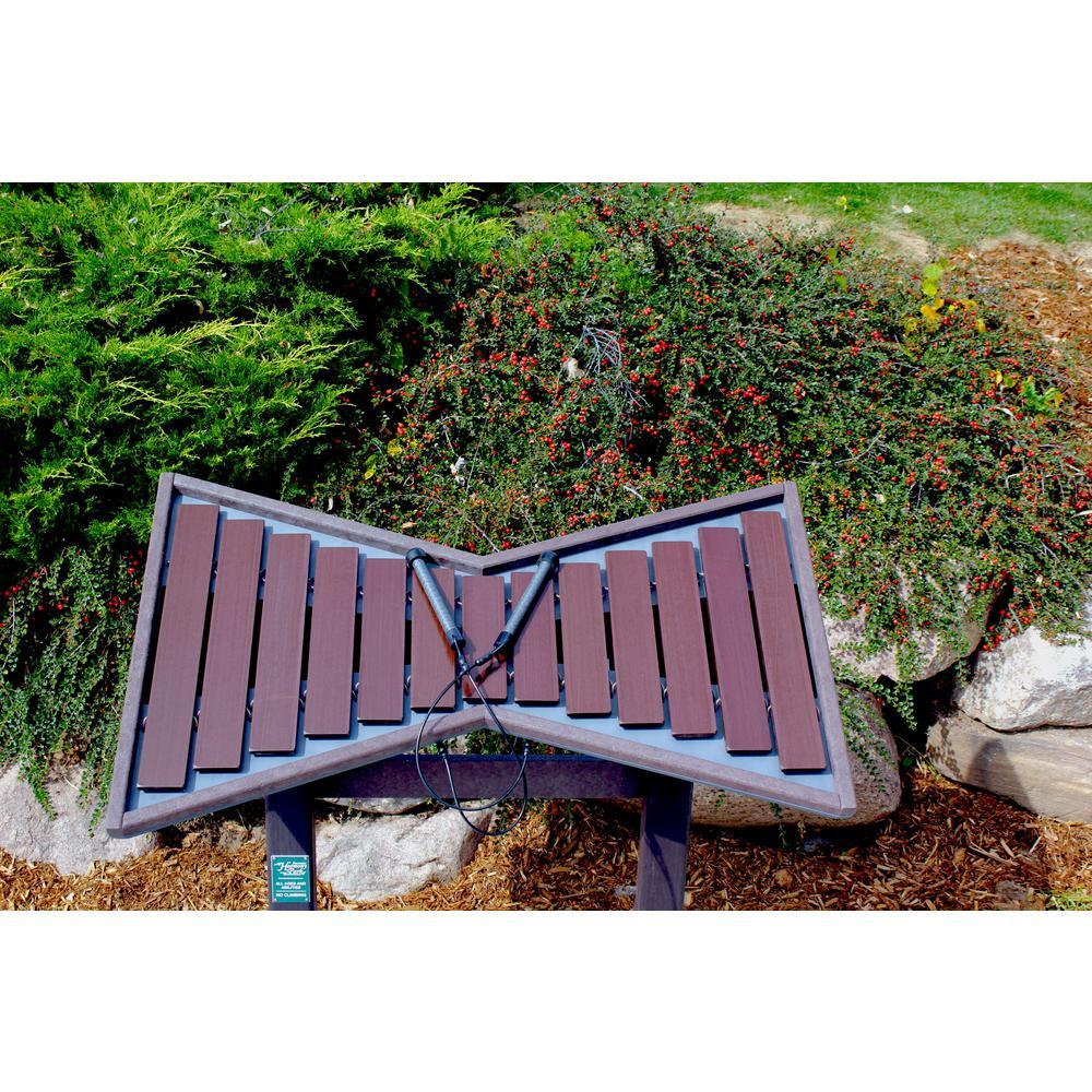Cadence Outdoor Musical Park Instrument tenor marimba with 13 dark brown fiberglass keys and two mallets set outdoors among greenery and rocks